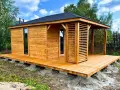 Drewniany domek narzędziowy z werandą, posadowiony na solidnym podłożu z bloczków betonowych.