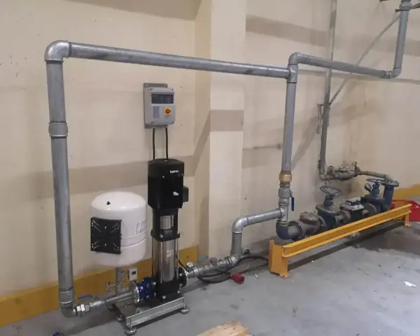 System pomp i zbiornik hydroforowy tworzą przyłącze wody. Metalowe rury prowadzą do zaworów i kolejnych pomp.