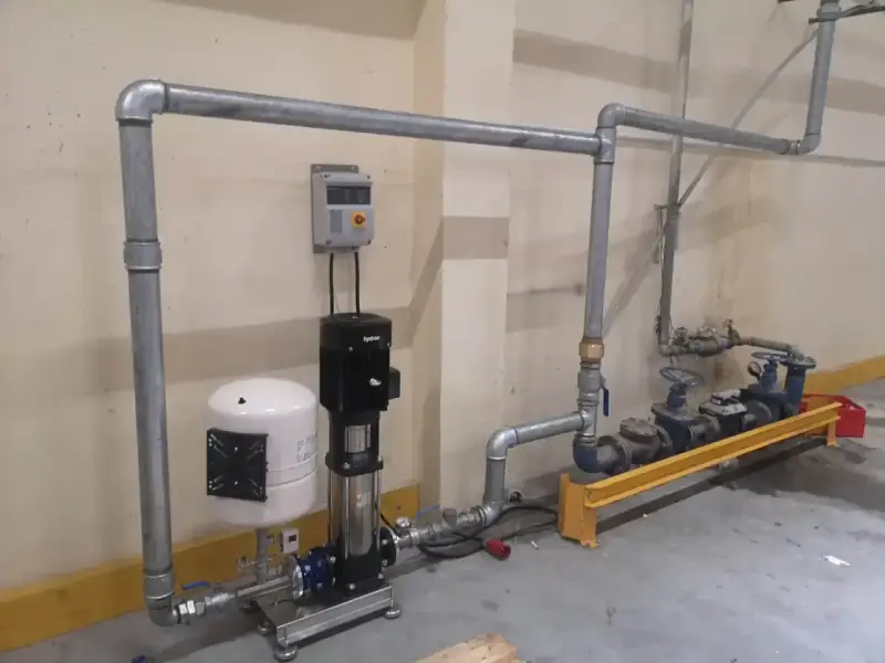 System pomp i zbiornik hydroforowy tworzą przyłącze wody. Metalowe rury prowadzą do zaworów i kolejnych pomp.